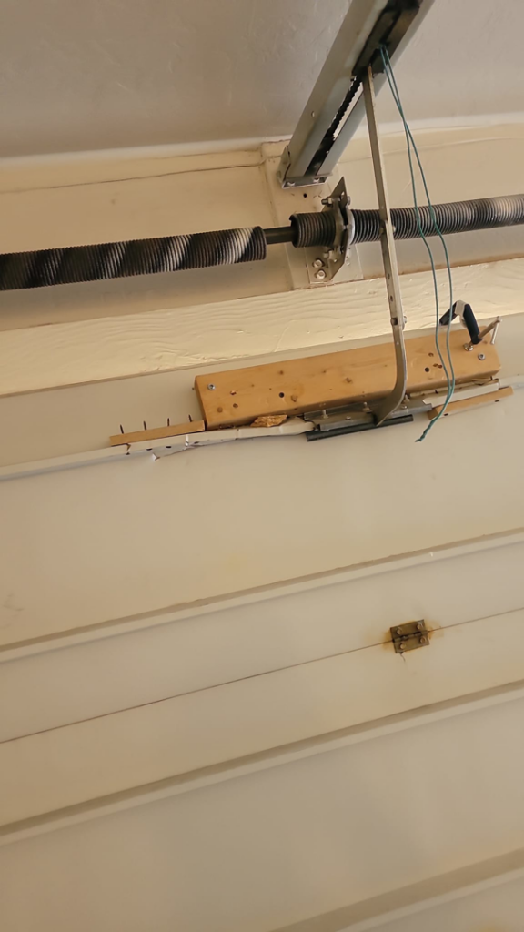 A close-up view of a garage door torsion spring system and tracks, indicating repair work by A1 Garage Guy Wes in Picture Rocks, AZ.
