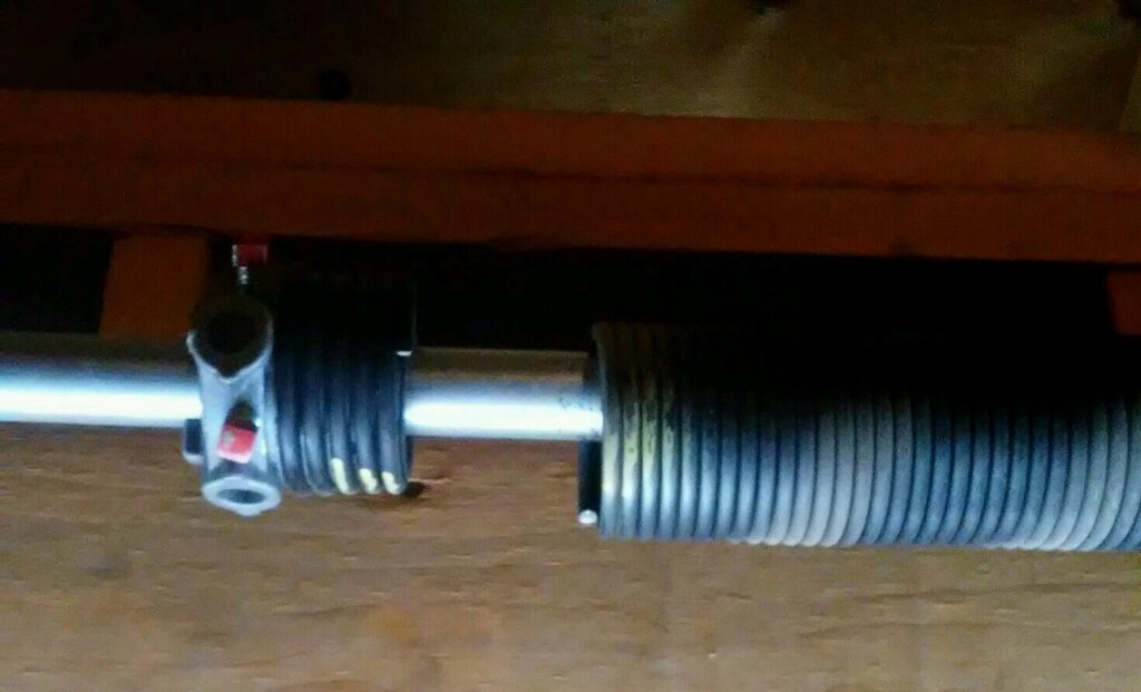 A close-up view of a garage door torsion spring system, showcasing components serviced by Sandia Garage Door Repair in Albuquerque, NM