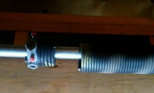 A close-up view of a garage door torsion spring system, showcasing components serviced by Sandia Garage Door Repair in Albuquerque, NM