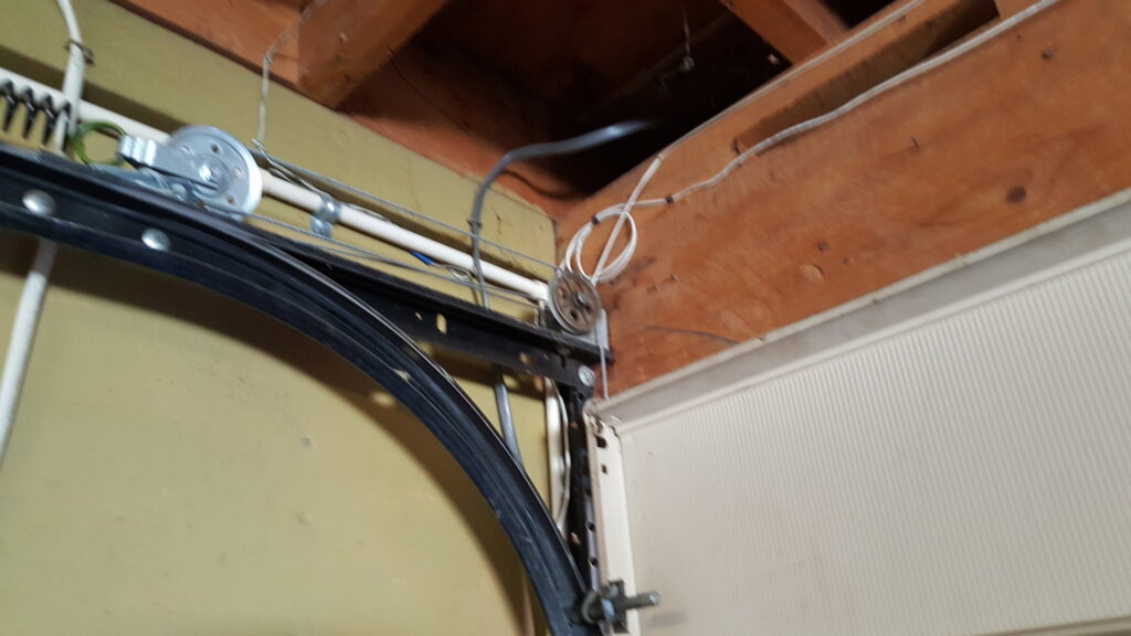 Close-up view of garage door tracks and cables during an inspection by Sandia Garage Door Repair in Albuquerque, NM