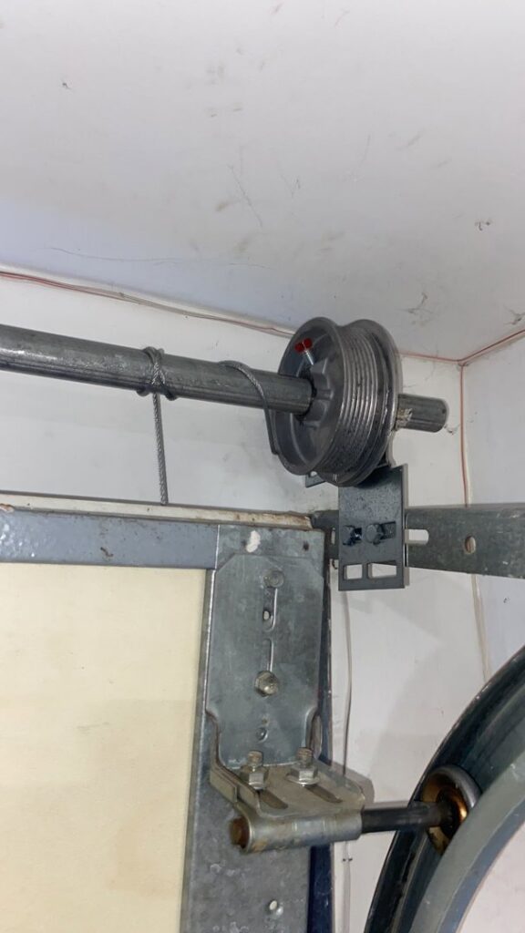 A close-up of garage door tracks and rollers, showing installation or repair work by DNA Garage Door Repair in New Haven, CT