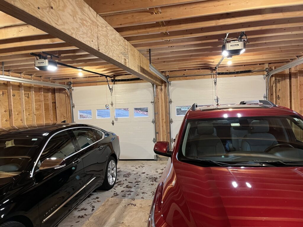 Interior view of a garage showing two installed garage doors and overhead openers by RidgeLine Overhead Garage Door of CT in Danbury, CT