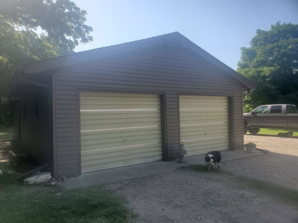 A garage with newly installed brown siding by River City Exteriors in San Antonio, TX