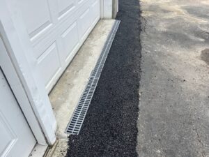 A new trench drain installed at a garage entrance by EFFECTIVE WATERPROOFING in Worcester, MA.