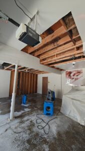 Garage with exposed ceiling and water damage drying equipment by 4 Seasons Restoration LLC in Midvale, UT.