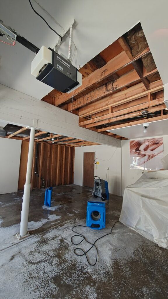Garage with exposed ceiling and water damage drying equipment by 4 Seasons Restoration LLC in Midvale, UT.