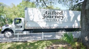 A large moving truck with the Gifted Journey Movers logo parked outside a residence in Gulfport, MS.