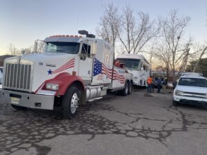 Giner's Towing heavy-duty tow truck preparing to tow a large RV in Aurora, CO.