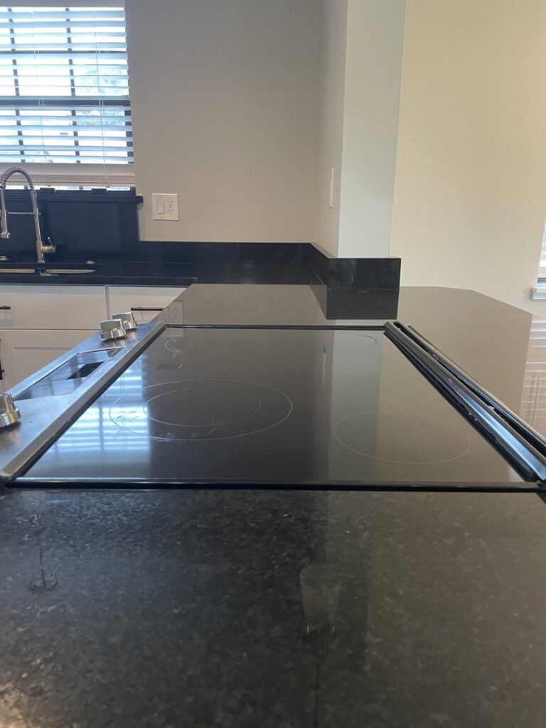 A gleaming black stovetop and countertop, meticulously cleaned by Maid In Indy in Indianapolis, IN.