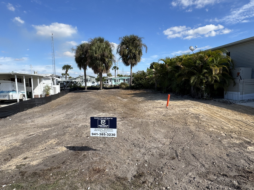 A cleared and graded dirt lot ready for development, showcasing demolition and site preparation by New Wave Concepts in Cape Coral, FL.