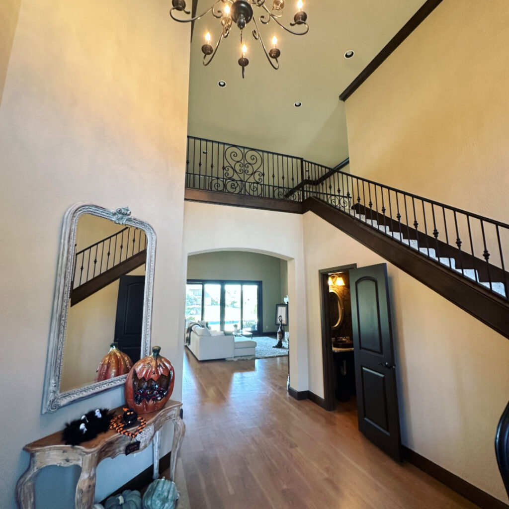A grand and clean entryway with a sweeping staircase and elegant console table, professionally cleaned by Inspire Clean OKC in Oklahoma City, OK.