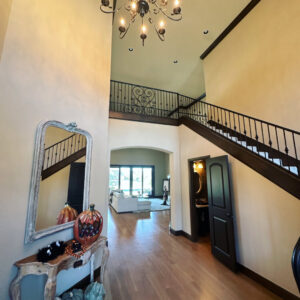 A grand and clean entryway with a sweeping staircase and elegant console table, professionally cleaned by Inspire Clean OKC in Oklahoma City, OK.