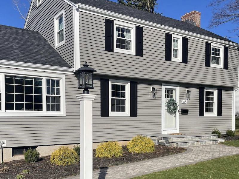 A beautiful home with newly installed gray horizontal siding and black shutters by Atlantic Roofing and Siding in East Hartford, CT.