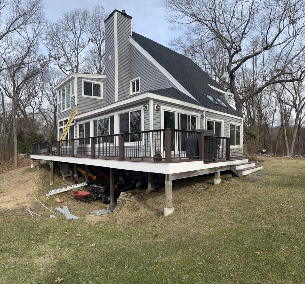 A house with new gray horizontal siding and a large deck, completed by Atlantic Roofing and Siding in East Hartford, CT.
