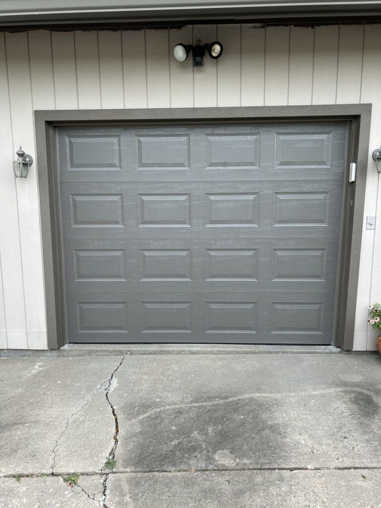 A newly installed gray residential garage door by Woodwards Overhead Door Co. in Topeka, KS
