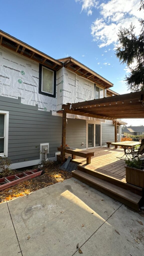A residential home with gray siding partially installed and house wrap visible, showing a siding project in progress by Bishop Exteriors in Omaha, NE.
