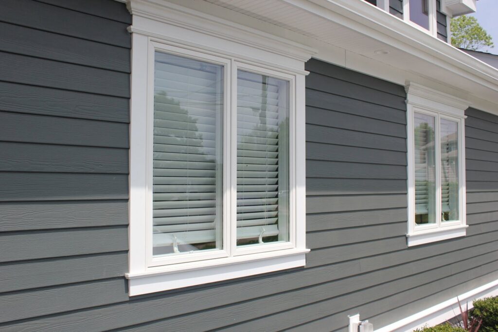 Close-up of gray siding with crisp white window trim by SmardBuild Siding and Exteriors in Naperville, IL