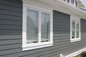 Close-up of gray siding with crisp white window trim by SmardBuild Siding and Exteriors in Naperville, IL
