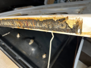 A very greasy and dirty oven edge, showing accumulated grime before professional cleaning by Masters Touch Cleaning Solutions LLC.