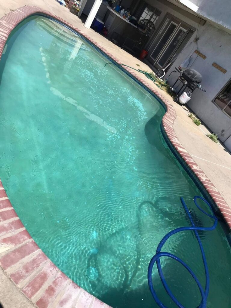 A green and dirty residential pool with a hose, awaiting professional cleaning from Bright Side Pool Service LLC in Broken Arrow, OK.