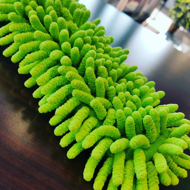 A close-up of a green microfiber duster, a tool used by Northern States Cleaning in Duluth, MN.