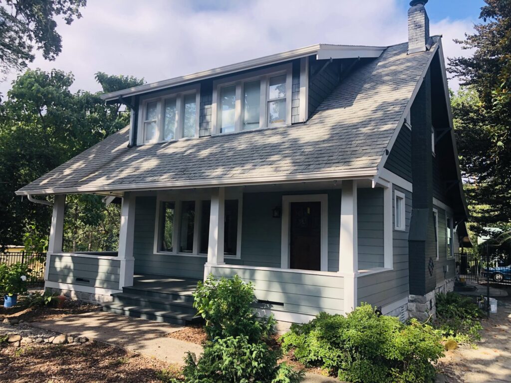 A house featuring new green siding and stone accents, a project by Preferred Exteriors in Roswell, GA