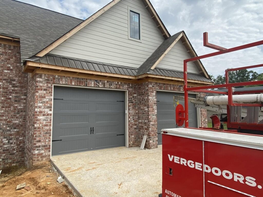 Installation of grey garage doors on a new construction home by Jonathan at Verge Entrance Solutions/Overhead Door in Hattiesburg, MS.