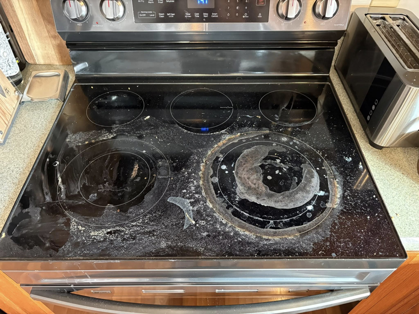 A grimy electric stovetop covered in spills and residue, showing a before-cleaning state by The Scrub Club in Concord, NH.