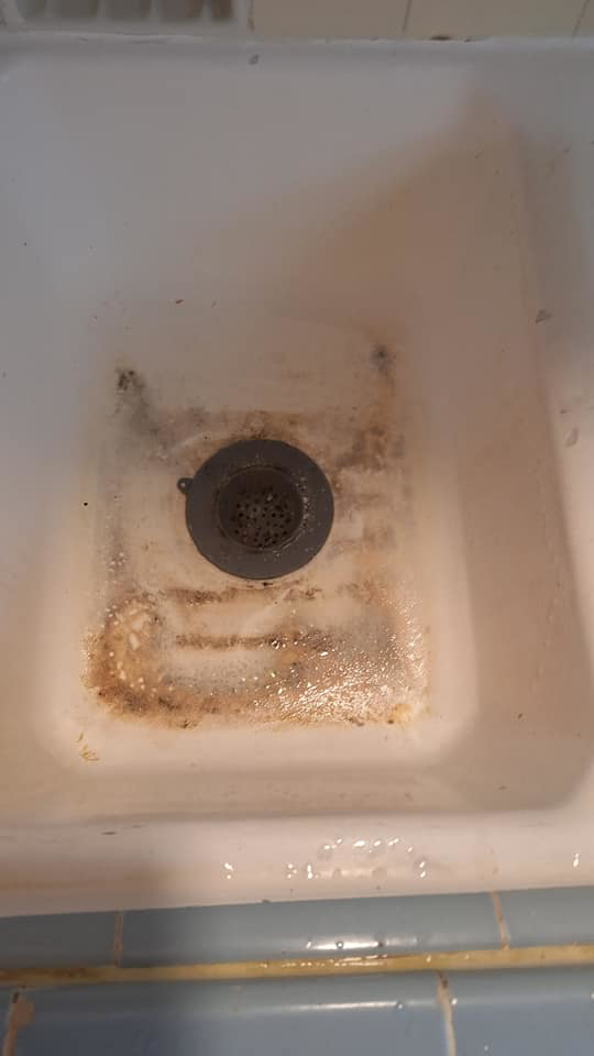 A grimy sink drain with rust and dirt before professional house cleaning by Quality Cleaning for Less in Los Angeles, CA.