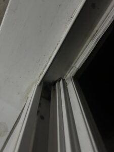 A detailed view of a grimy window sill and track, indicating a need for thorough cleaning from A+ Residential Cleaning Services in Champaign, IL.