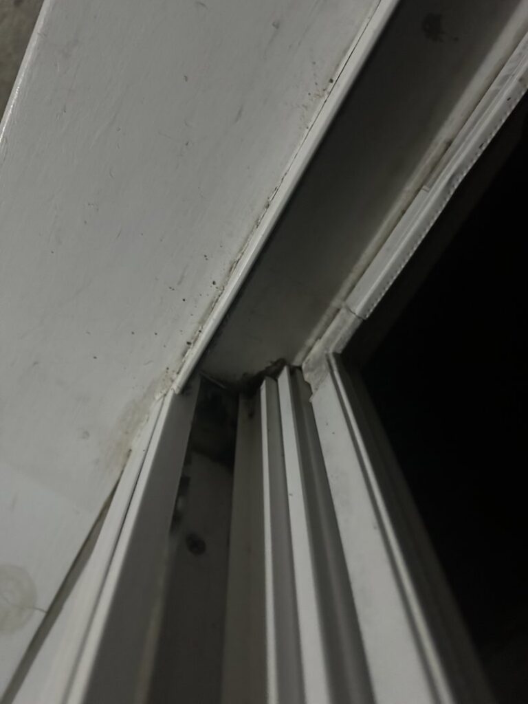 A detailed view of a grimy window sill and track, indicating a need for thorough cleaning from A+ Residential Cleaning Services in Champaign, IL.