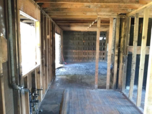 Gutted building interior with exposed wooden studs and plumbing, demonstrating demolition services by Building Assisting Group Demolition INC in Tacoma, WA.