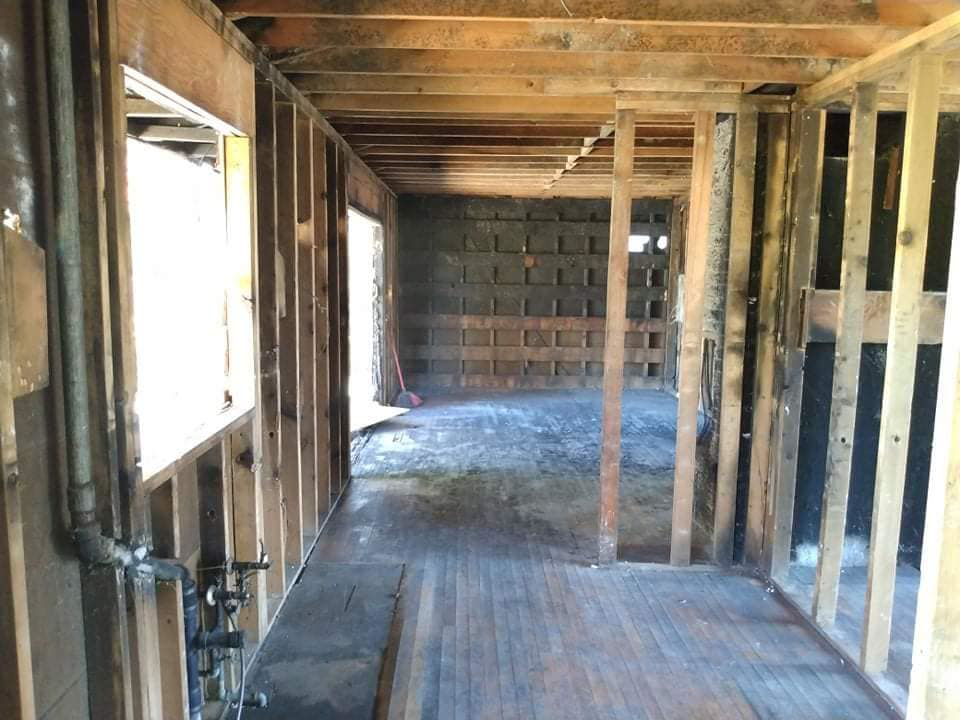 Gutted building interior with exposed wooden studs and plumbing, demonstrating demolition services by Building Assisting Group Demolition INC in Tacoma, WA.