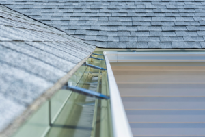 A clean gutter system with protective guards installed to prevent water damage by Papillion Windows & Siding - NE in Papillion, NE.