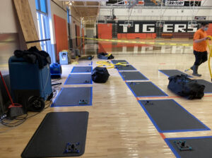 A gym floor being dried with specialized mats and dehumidifiers by Paul Davis Restoration of Portland / Vancouver in Vancouver, WA