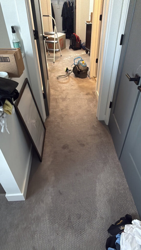 A hallway with carpet and drying equipment in the background, indicating active water damage restoration by Utah Disaster Specialists in Syracuse, UT.
