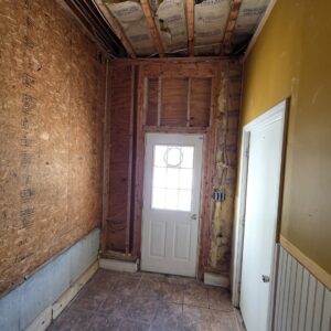 A hallway with walls stripped to studs, showing remediation work by PuroClean of Strafford County in Nottingham, NH.