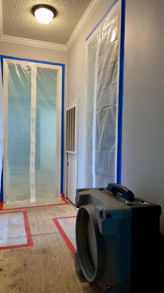 Hallway with plastic containment and a large dehumidifier for water damage remediation by 1st Response Emergency Repairs, LLC in Scott, LA.