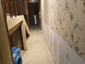A hallway with removed drywall and drying equipment for water damage restoration by Anytime Flood Restoration in Thornton, CO