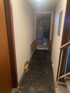 A hallway with walls removed for water damage remediation, showing the extent of the damage at ServiceMaster of Salt Lake in Salt Lake City, UT
