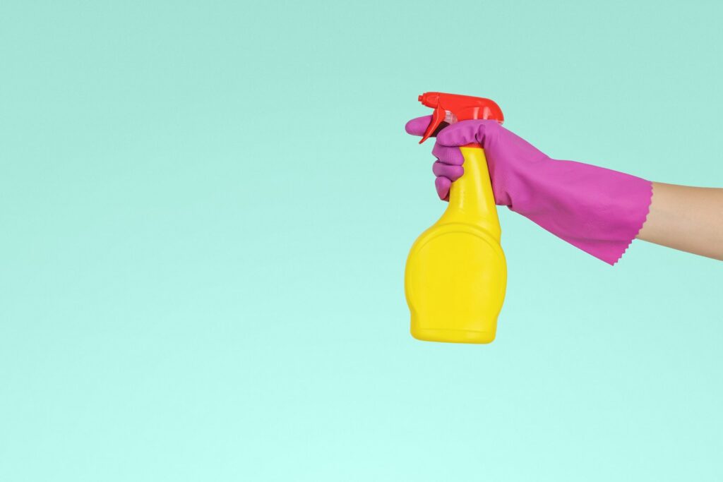 A gloved hand holding a spray bottle, representing cleaning services from Platt Cleaning Services in Lafayette, LA.