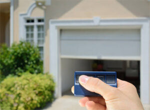 A hand holding a remote control opening a garage door, demonstrating services by K & B Door Co. in Las Vegas, NV