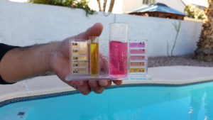 A hand holding a pool water testing kit to check chemical levels by Bluemar Pool & Spa Services in North Las Vegas, NV.