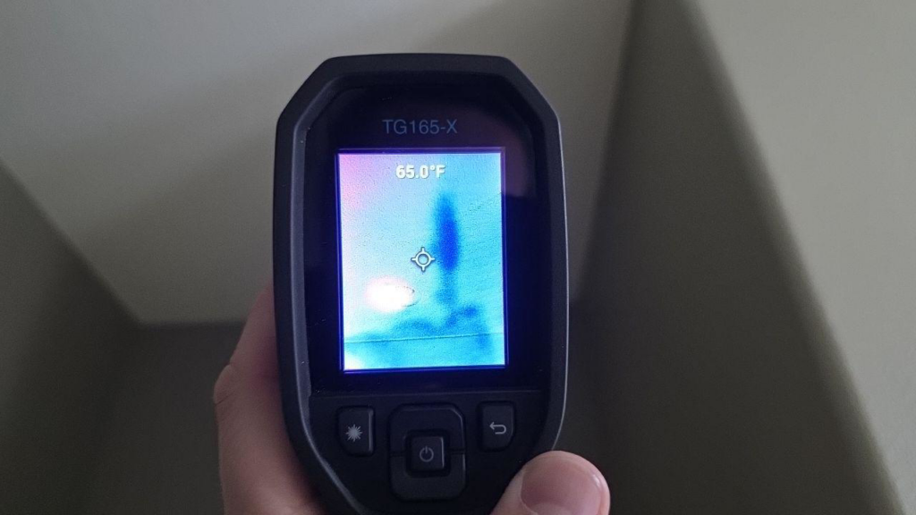 A hand using a thermal imaging camera to detect hidden moisture in a wall or ceiling for Restoration Techs, LLC in Oregon City, OR.