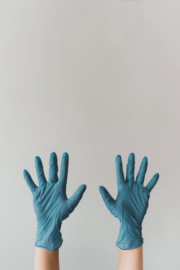 A pair of hands wearing blue protective gloves, symbolizing the cleaning work by Platt Cleaning Services in Lafayette, LA.