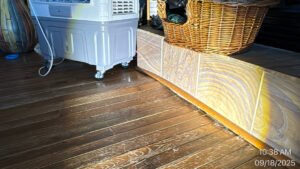 A room with hardwood floors and a large dehumidifier actively drying the area after water damage in Syracuse, UT by Utah Disaster Specialists.