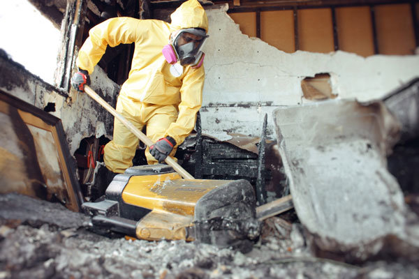 A worker in a hazmat suit removing debris from a damaged area during restoration by Island Restoration LLC in Kapolei, HI.