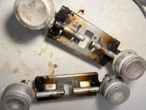 Heavily soiled stove burner components with burnt-on grease, before professional cleaning by Masters Touch Cleaning Solutions LLC.