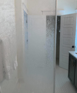 A heavily spotted and dirty glass shower enclosure, demonstrating a common cleaning challenge for Quality Cleaning in Summerville, SC.