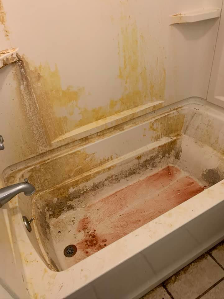 A heavily stained and grimy bathtub before a deep cleaning service by Tip Top Cleaning in Champaign, IL.